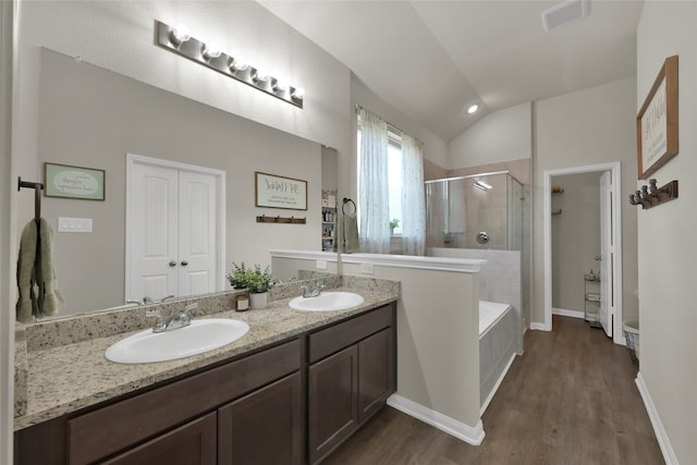 bathroom with vanity, vaulted ceiling, hardwood / wood-style flooring, and independent shower and bath