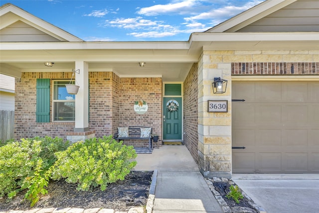 doorway to property with a garage and covered porch