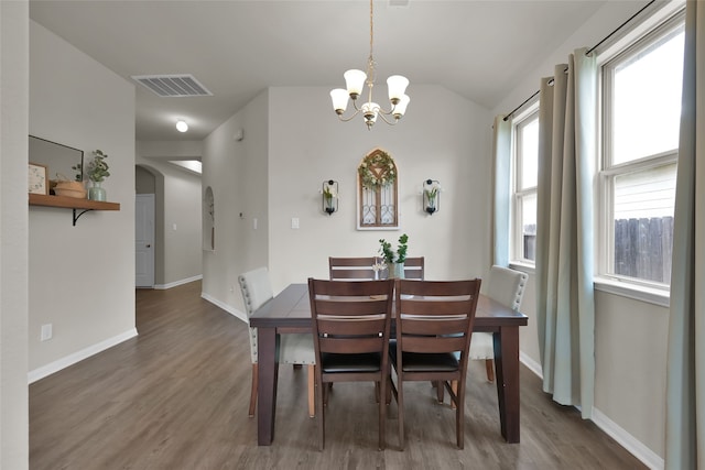 dining room with plenty of natural light, an inviting chandelier, and dark hardwood / wood-style flooring