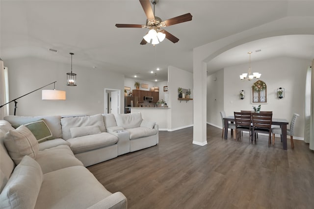 living room with dark wood-type flooring, vaulted ceiling, and ceiling fan with notable chandelier