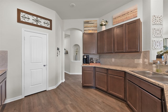 kitchen with backsplash, sink, dark brown cabinetry, and dark hardwood / wood-style floors