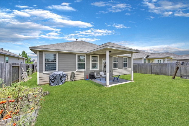 back of house with a patio area and a yard