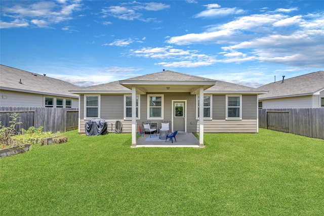 rear view of property featuring a yard and a patio