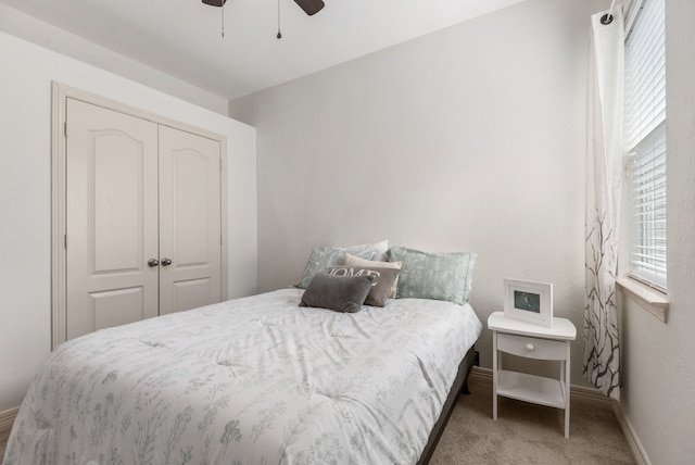 carpeted bedroom featuring a closet and ceiling fan