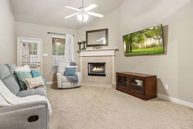 living room with lofted ceiling, a tiled fireplace, ceiling fan, and carpet flooring