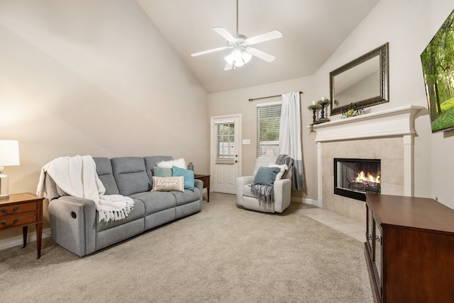 carpeted living room with a fireplace, ceiling fan, and high vaulted ceiling