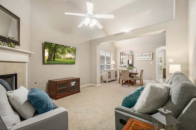 living room featuring ceiling fan, lofted ceiling, light carpet, and a fireplace