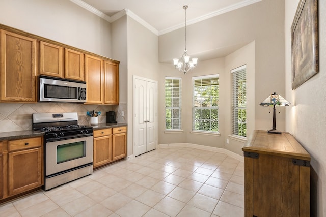 kitchen with a chandelier, tasteful backsplash, hanging light fixtures, stainless steel appliances, and light tile patterned floors