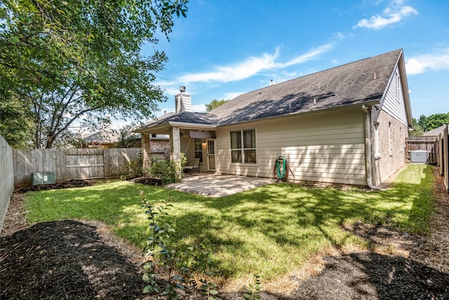 back of house featuring a lawn and a patio