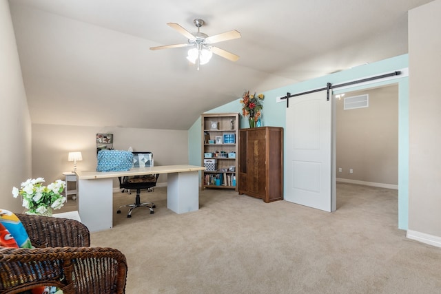 carpeted office space with ceiling fan, a barn door, and vaulted ceiling