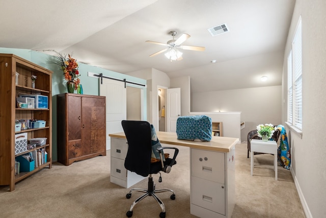 carpeted office featuring ceiling fan, vaulted ceiling, and a barn door