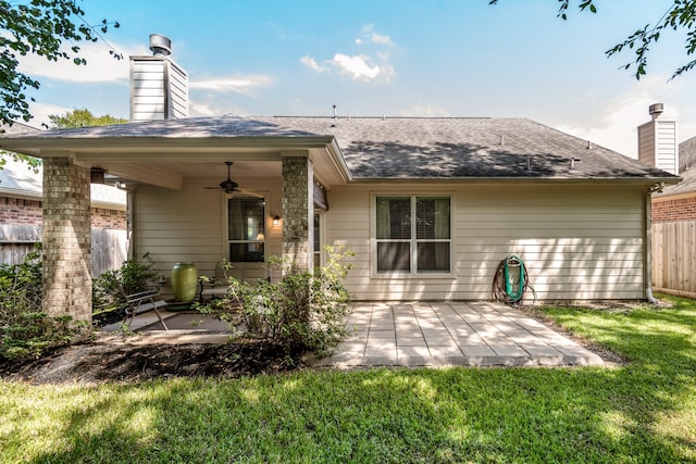 rear view of house with ceiling fan, a lawn, and a patio area