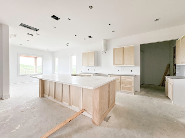 kitchen with light brown cabinetry and a center island