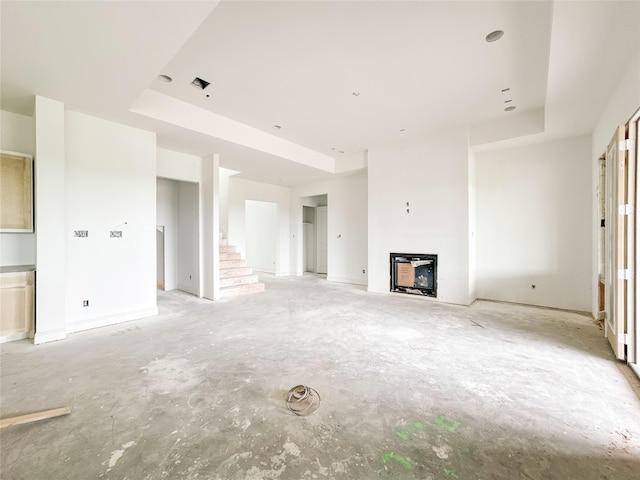 unfurnished living room featuring a raised ceiling