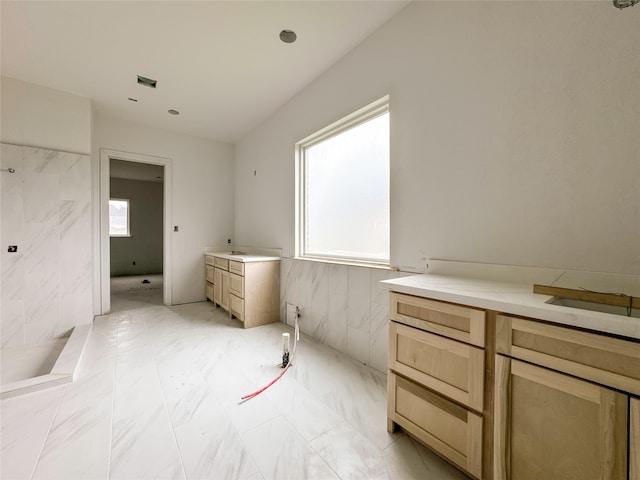 bathroom with vanity and tile walls