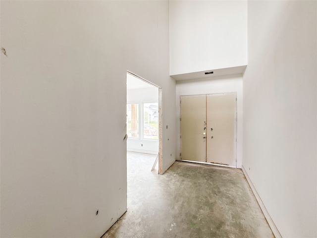 corridor featuring a towering ceiling