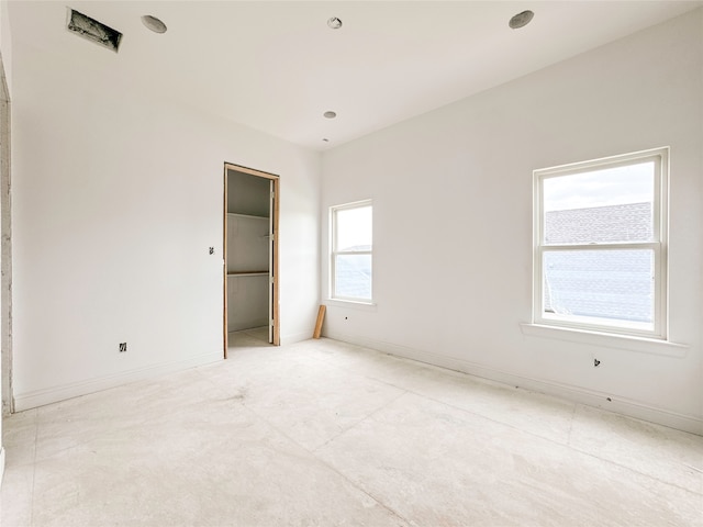 unfurnished bedroom featuring multiple windows and a closet