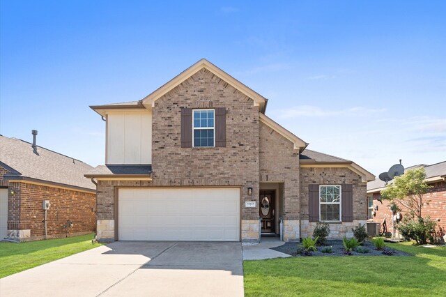 view of front facade with a front yard, central AC, and a garage