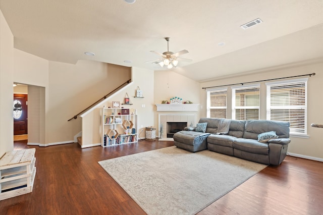 living room featuring lofted ceiling, ceiling fan, a fireplace, and dark hardwood / wood-style flooring