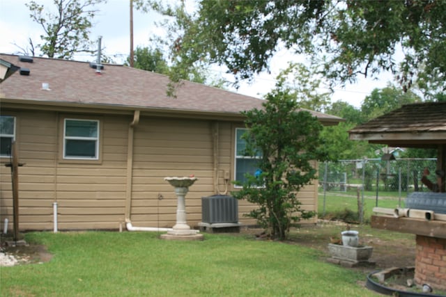 back of house featuring a yard and central AC unit