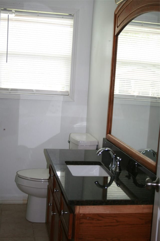 bathroom with toilet, a wealth of natural light, and vanity