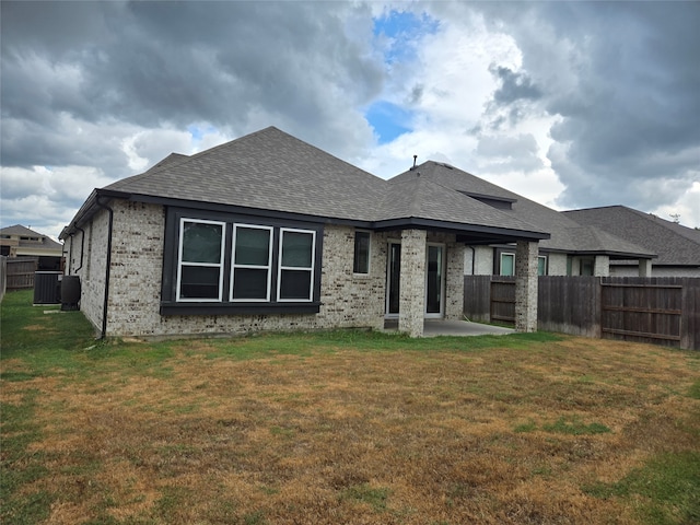 rear view of property featuring a yard, central AC, and a patio