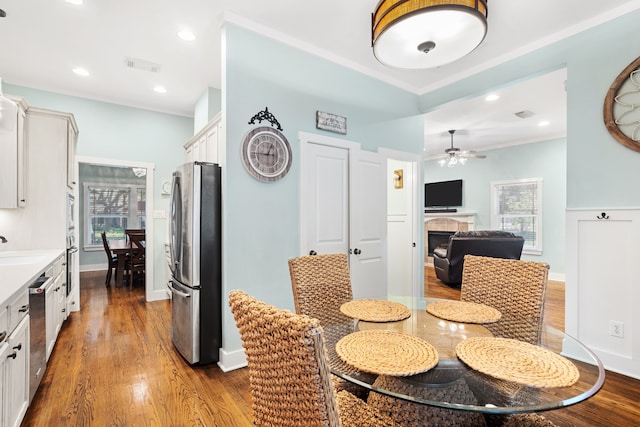 dining space featuring a tile fireplace, ceiling fan, sink, and light hardwood / wood-style floors