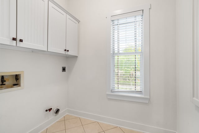 washroom with cabinets, electric dryer hookup, gas dryer hookup, hookup for a washing machine, and light tile patterned floors