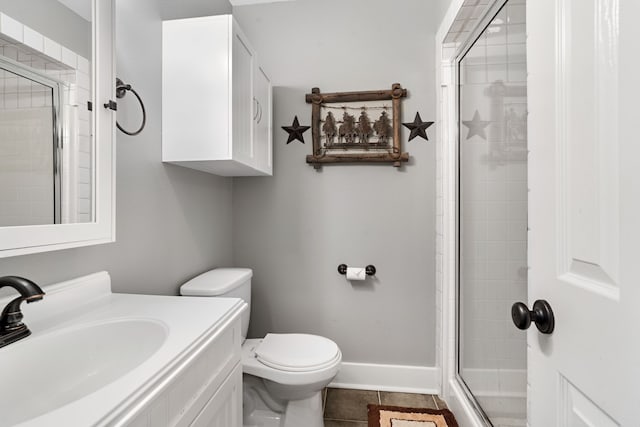 bathroom with toilet, vanity, tile patterned floors, and a shower with shower door