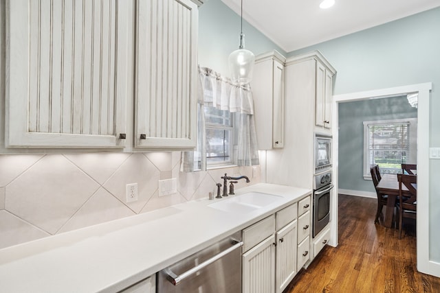 kitchen featuring dark wood-type flooring, sink, decorative backsplash, decorative light fixtures, and stainless steel appliances