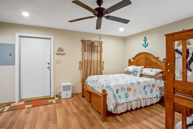 bedroom with electric panel, light hardwood / wood-style flooring, and ceiling fan