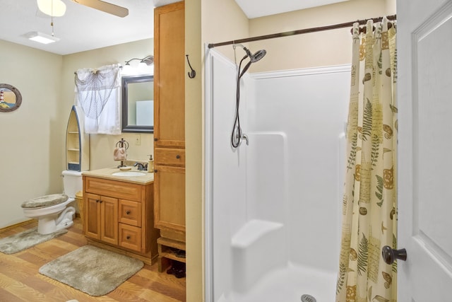 bathroom featuring toilet, walk in shower, vanity, ceiling fan, and hardwood / wood-style flooring