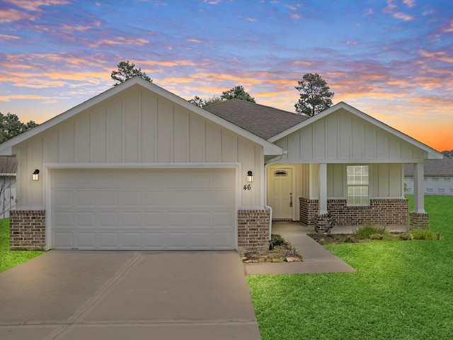 single story home with covered porch, a lawn, and a garage