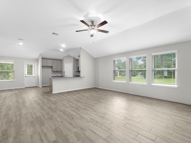 unfurnished living room featuring light hardwood / wood-style flooring, ceiling fan, and vaulted ceiling