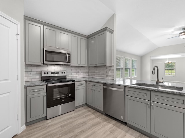 kitchen featuring stone countertops, gray cabinetry, sink, and appliances with stainless steel finishes