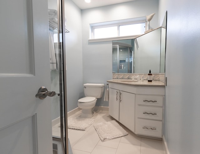 bathroom featuring toilet, vanity, tile patterned floors, and an enclosed shower