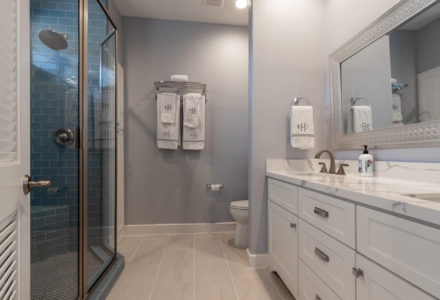 bathroom with tile patterned flooring, toilet, vanity, and walk in shower