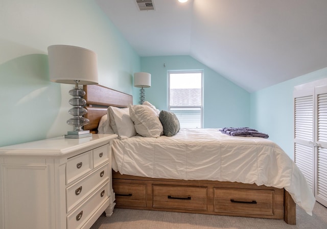 bedroom with light colored carpet and vaulted ceiling