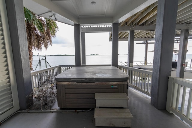 exterior space featuring a water view and a hot tub