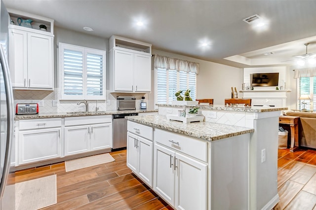 kitchen with dishwasher, light hardwood / wood-style floors, white cabinetry, and a wealth of natural light