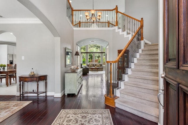 foyer featuring ornamental molding, a high ceiling, dark hardwood / wood-style floors, and a notable chandelier