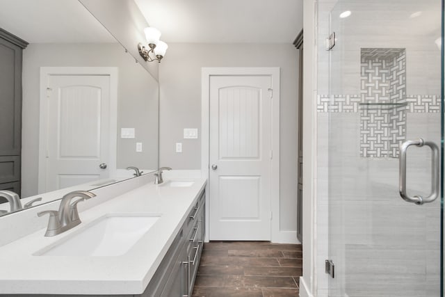 bathroom featuring a shower with shower door, hardwood / wood-style flooring, and vanity