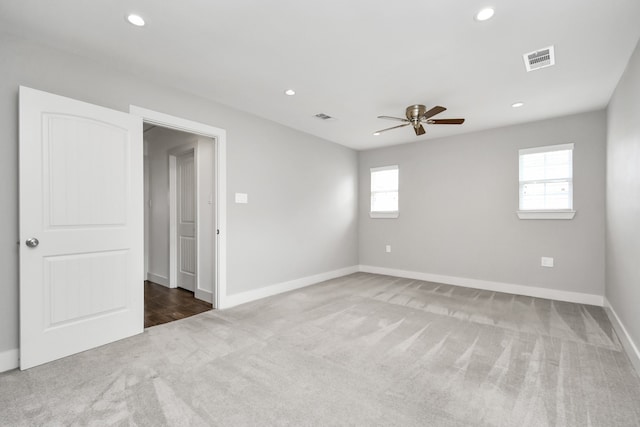 carpeted spare room with a wealth of natural light and ceiling fan