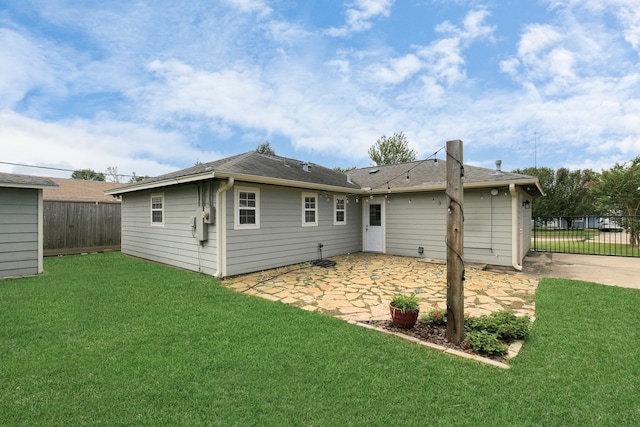 rear view of house featuring a patio area and a lawn