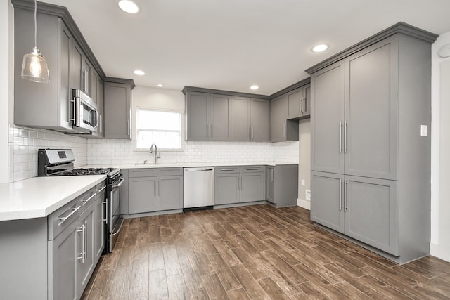 kitchen featuring gray cabinets, stainless steel appliances, and dark hardwood / wood-style floors