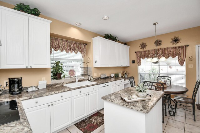 kitchen featuring light tile patterned flooring, a center island, white cabinets, and decorative light fixtures