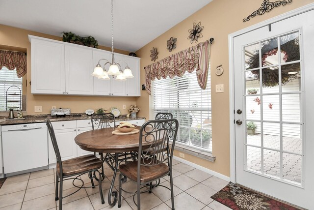 dining room featuring a healthy amount of sunlight, a notable chandelier, light tile patterned floors, and sink