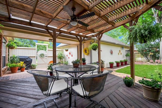 deck featuring area for grilling, ceiling fan, a yard, and a pergola