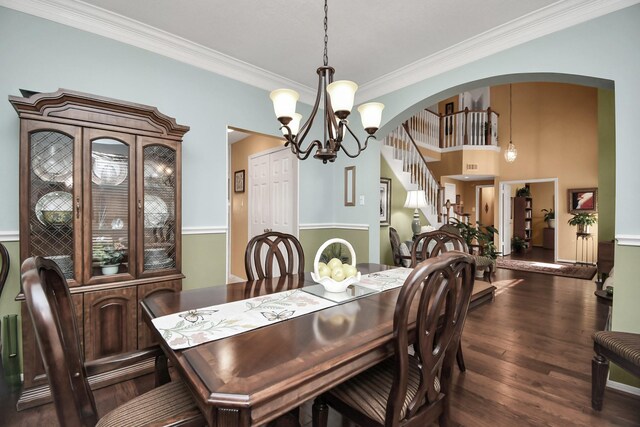 dining area with dark wood-type flooring, a chandelier, and crown molding