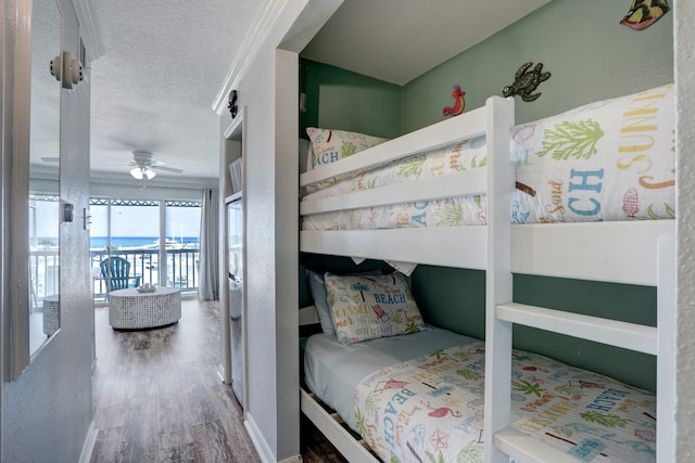 bedroom featuring ornamental molding, a textured ceiling, access to outside, wood-type flooring, and ceiling fan